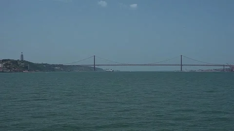 Boat sailing on the tagus river with a view of the 25th of April bridge Stock Footage 311339521
