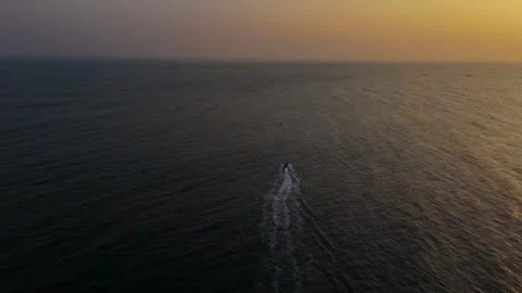 A boat sailing through the sea in the evening with the sunset drone shot Stock Footage 305214559