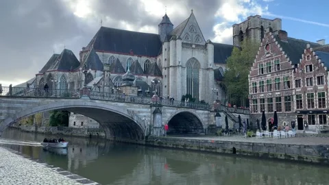 Boat is sailing under arched stone bridge. Saint Michael church. Ghent, Belgium Stock-Footage 294053052