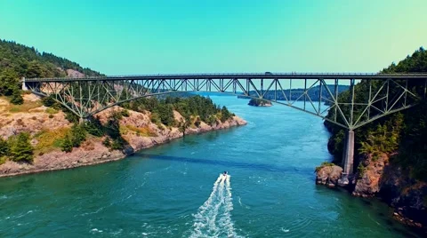 Boat sailing under a bridge by oceanfront on a sunny day Stock-Footage 53307196