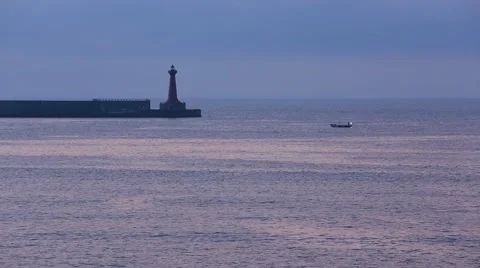 Boat sailing under guide of the lighthouse in the sunset Stock Footage 52296305