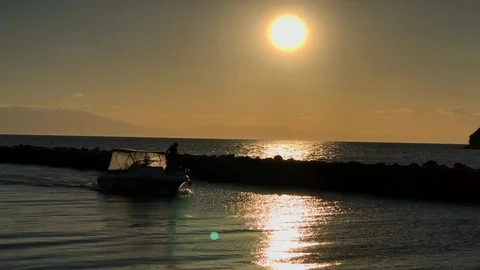 A boat sails during sunset in Greece Stockbeeldmateriaal 109150519
