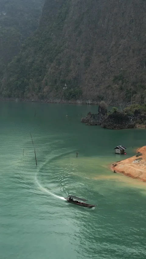 A boat sails on a lake between mountains Stock Footage 267595224