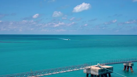 Boat sails in the ocean waves moves to the bridge by the coast Video stock 108936852