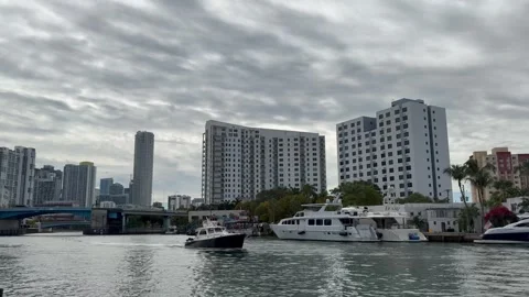 Boat sails through Miami river. Movement of cars traffic on drawbridges. Florida Stockbeeldmateriaal 328348287