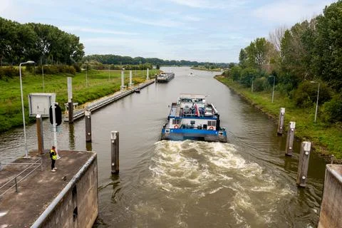 A boat sails through the sluice at the river 'the Maas" Stock Photos