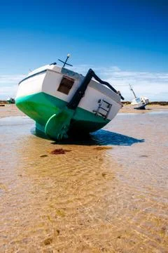 Boat on sand with waves Stock Photos