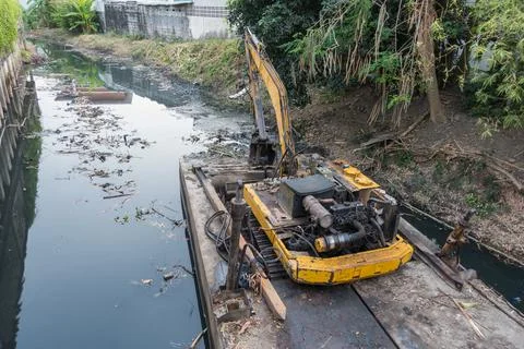 Boat scoop mud dredging the canal in bangkok canal in thailand Stock Photos