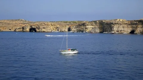 A boat at sea with rocks on the background Vídeos de archivo 96609534