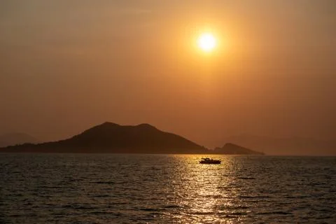 Boat at sea while sun sets Stock Photos