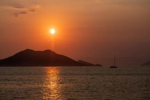 Boat at sea while sun sets Stock Photos