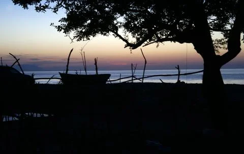 A boat on the shore posing to the camera while sun is falling down Stock Photos