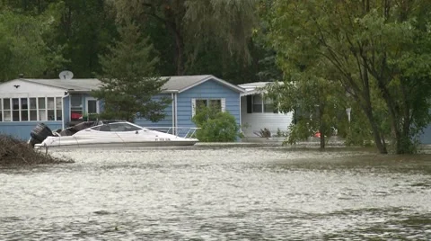 A boat sits outside a flooded mobile home shortly after Hurricane Irene Stock Footage 8567325