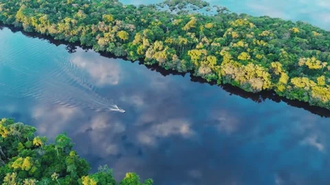 Boat on smooth Amazon river with cloud patterns reflected Stock Footage 322127522