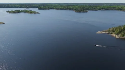 A boat is speeding across the lake between rocky islands. The nature of Video stock 312471606