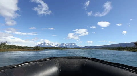 Boat speeding down river revealing mountains Stock Footage 50961810