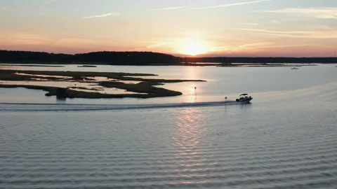 Boat Speeding Through the Bay at Sunset Stock Footage 136025603