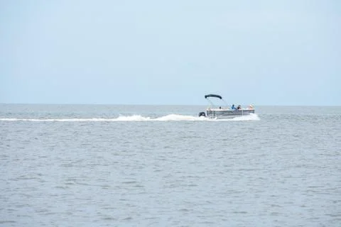 A Boat Speeding Through the Ocean on an Overcast Day Stock Photos
