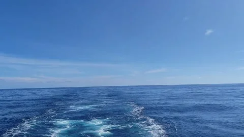 Boat speeding through vast blue ocean leaving white foam wake video footage Stock Footage 344369063