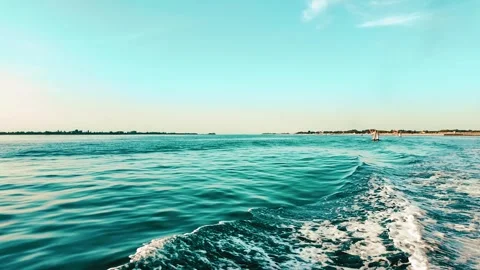 A boat splits the seawater before sunset Stock Footage 280776591