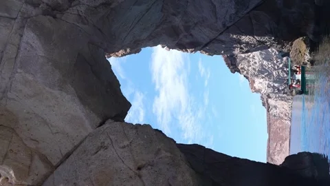 Boat tour exploring Isla Espiritu Santo passing thru a rock arch, Baja Stock Footage 278220993
