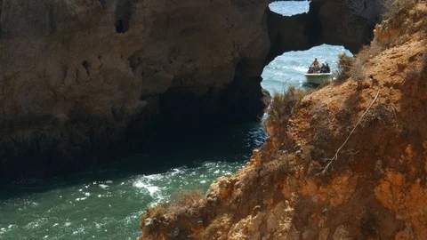 Boat with tourists enter the Ponta da Piedade to explore its fascinating rock Stock Footage 115883390