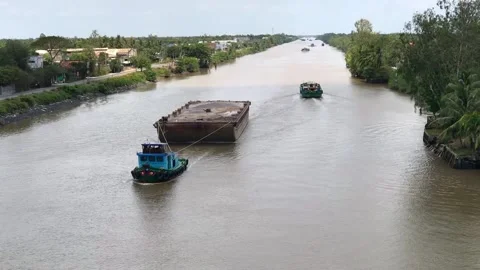Boat tows a barge on a river in Long An province, Mekong delta, Vietnam Stock Footage 142674959