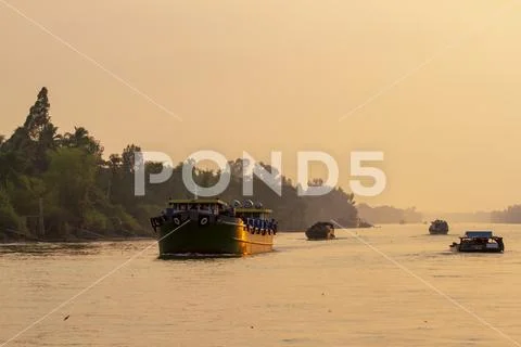 Boat traffic on Mekong River in Vietnam at sunset Stock Photos