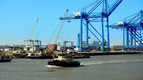 Boat traffic moves past loading docks in the port of Savannah, Georgia Stock Footage 303165726
