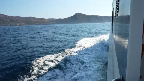 Boat trip leaving white trail on blue water near roses, girona Stock Footage 315867751