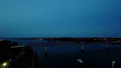 Boat under lighted bridge Stock Footage