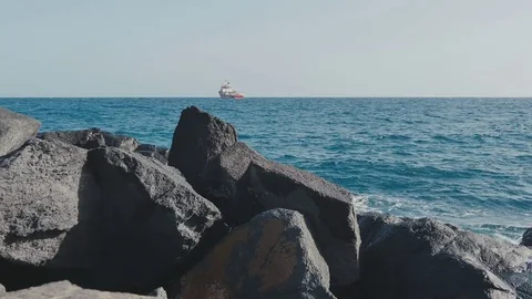 Boat view ocean waves stones Stock Footage 70410989