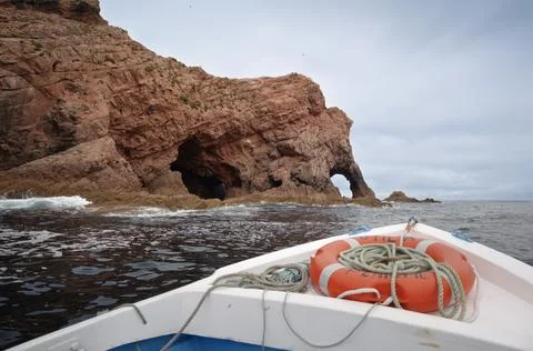 Boat View of Red Rock Cliffs and Sea Caves Stock Photos