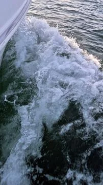 Boat wake churning through open water Stock Photos