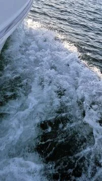 Boat wake splashing through open water Stock Photos