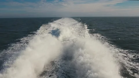 Boat wake trailing across the deep blue ocean toward the horizon Stock-Footage 327417562