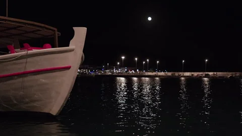 A boat is in the water with a full moon in the background 스톡 동영상 320672946
