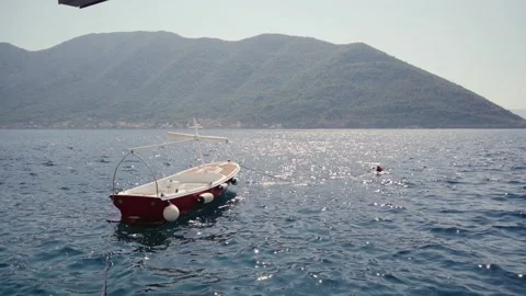 Boat on the waves against the backdrop of Mount Montenegro Stock Footage 302099500