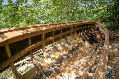 Boatbuilder Works Inside Framed Thai Long-Tail Boat Hull Stock Photos