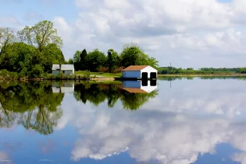 Boathouse reflected in river Stock Photos