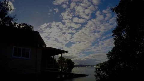 Boathouse with yachts in the background and clouds passing overhead. Time lapse Video stock 76169789