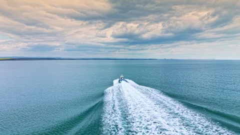 Boating on a calm sea with a cloudy sky in the distance near the coast during 스톡 동영상 342484975