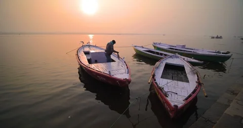Boatman rowing paddle and taking tourist at sunrise in Holy river Ganges Stock Footage 125230062