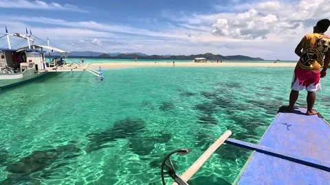 A Boatman Standing While Approaching a White Sandbar in Palawan Philippines Stock Footage 233763718