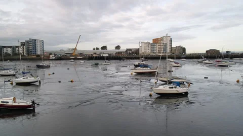 Boats aground in mud during low tide in Granton Harbour in Edinburgh, UK - 4K Stock Footage 253587681