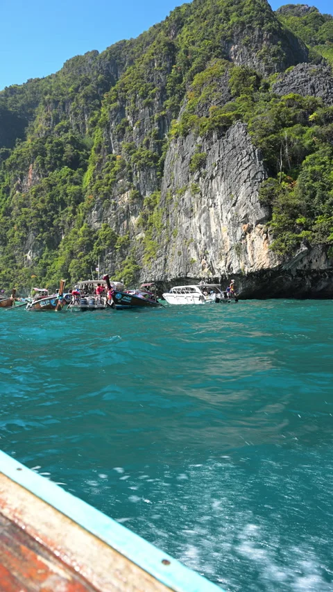 Boats Anchored Beneath Towering Limestone Cliffs at Phi Phi Islands Vídeos de archivo 337461748