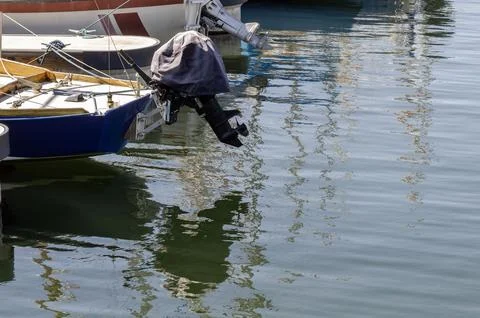 Boats and floating docks reflected in calm marina water under bright sunlight Stock Photos