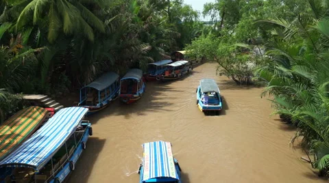 Boats are floating down to a river with muddy water in the vietnamese jungle Video stock 67426043