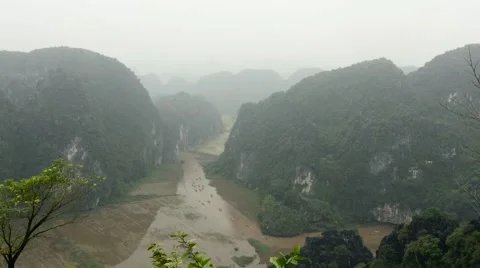 Boats between limestone mountains and rice fields, Vietnam. Extreme long shot. Stock Footage 65476435