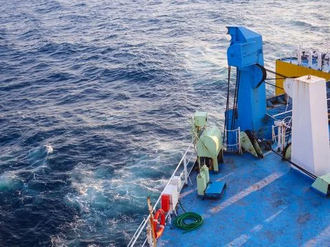A boat's blue deck with a white railing Foto stock